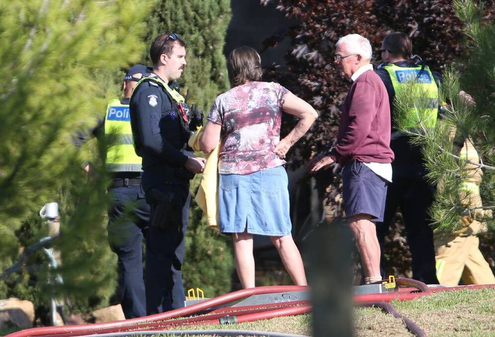 Pam and Brian Waldron, pictured with emergency services outside their damaged West Wodonga home on Friday morning. Picture by Blair Thomson