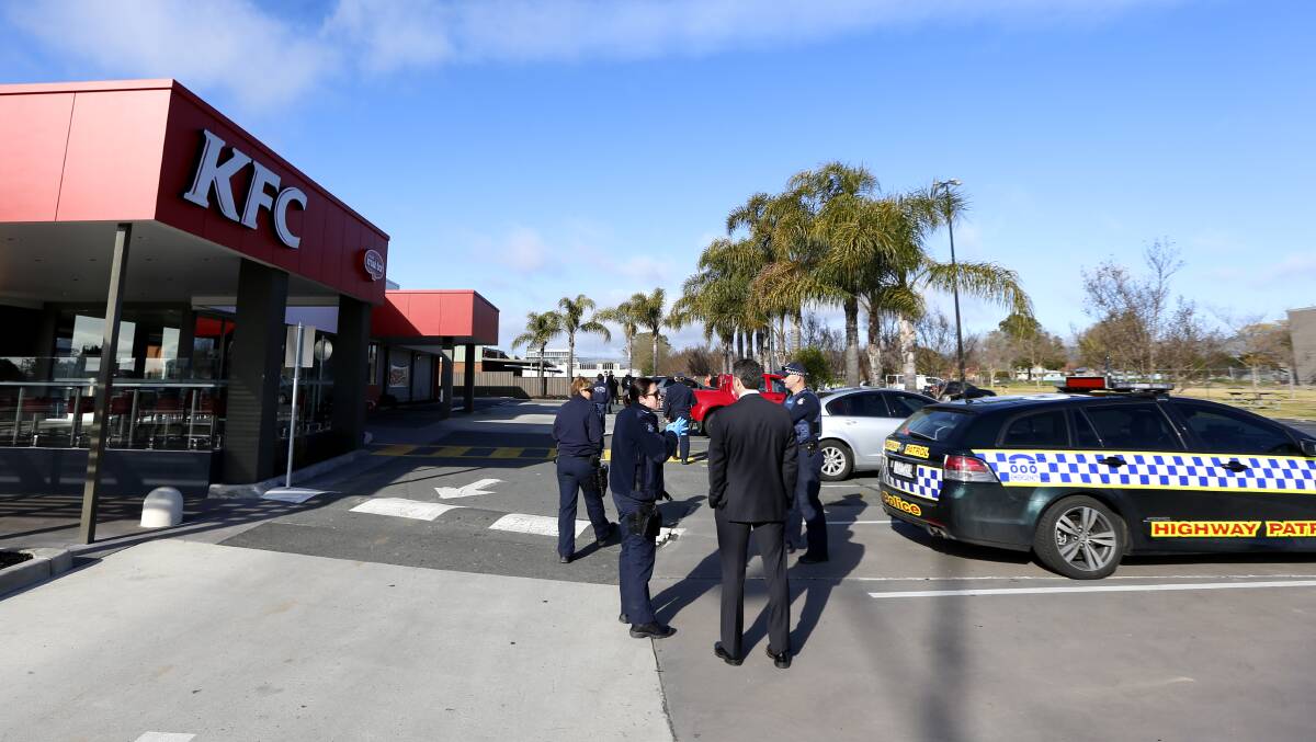 TARGET: Police outside the KFC on Elgin Boulevard the morning after the incident. 