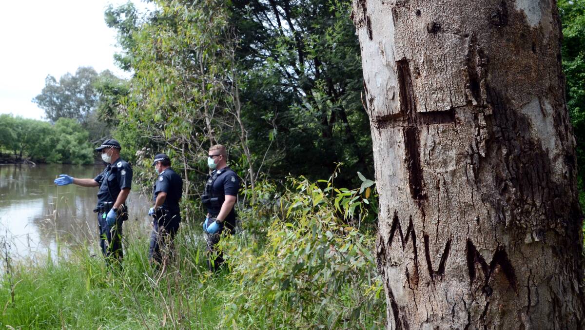 SEARCH: Police search Neils Reserve in November last year. It was the last known place the couple stayed. One of Ms Ridley's sons left a tribute to the late woman in a tree at the site. 