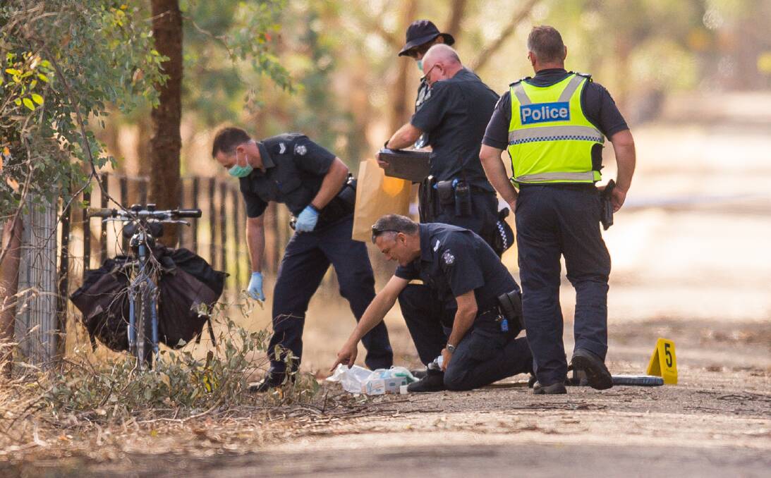 CRIME SCENE: Police on the rail trail at Everton following the shooting last February. The identity of the shooter remains unclear, but detectives hope someone has a clue that will help them solve the case. 