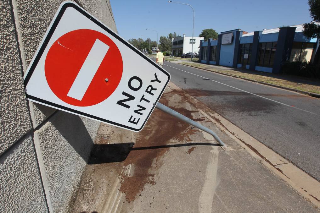 DAMAGED: The car hit the Fallon Street bridge and took out a road sign. Police are still trying to track down the driver of the unregistered car. Picture: BLAIR THOMSON