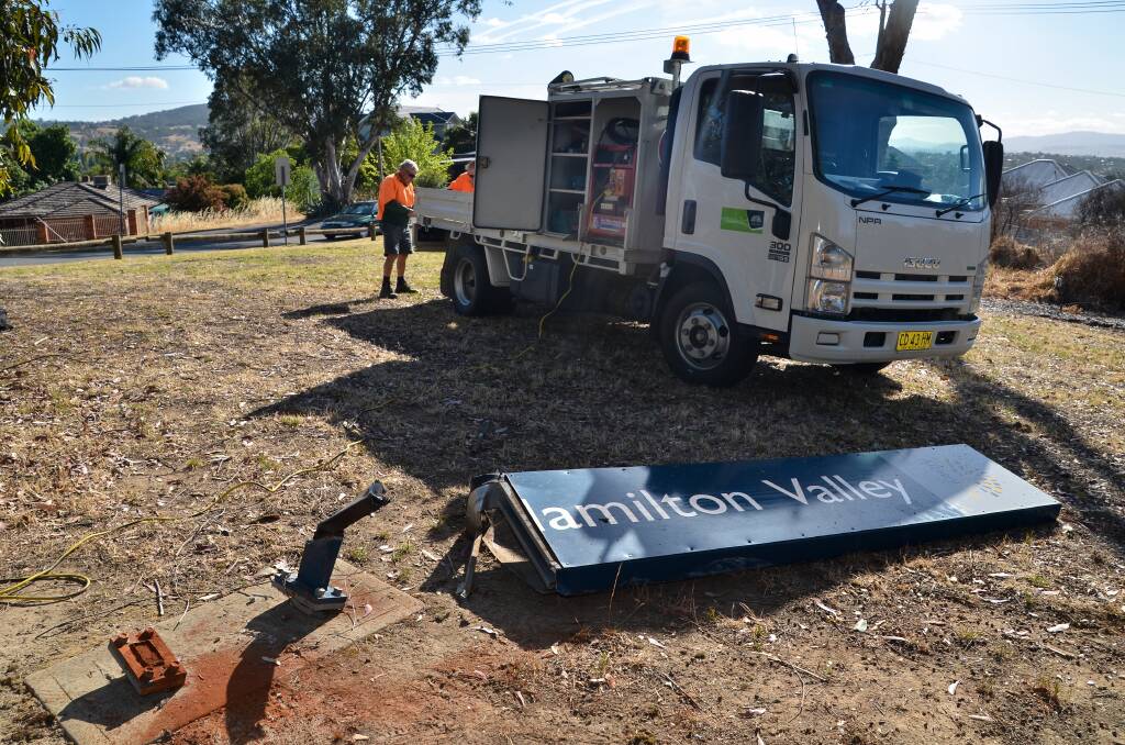 KNOCKED OUT: Council staff prepare to remove the damaged Hamilton Valley street sign on Wednesday. Picture: BLAIR THOMSON