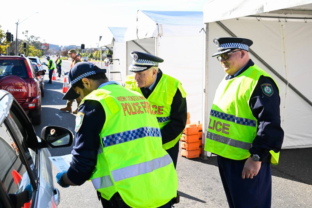 BORDER: Police officers, including Commissioner Mick Fuller (centre) and Assistant Commissioner Scott Whyte (right), at the checkpoint recently. 
