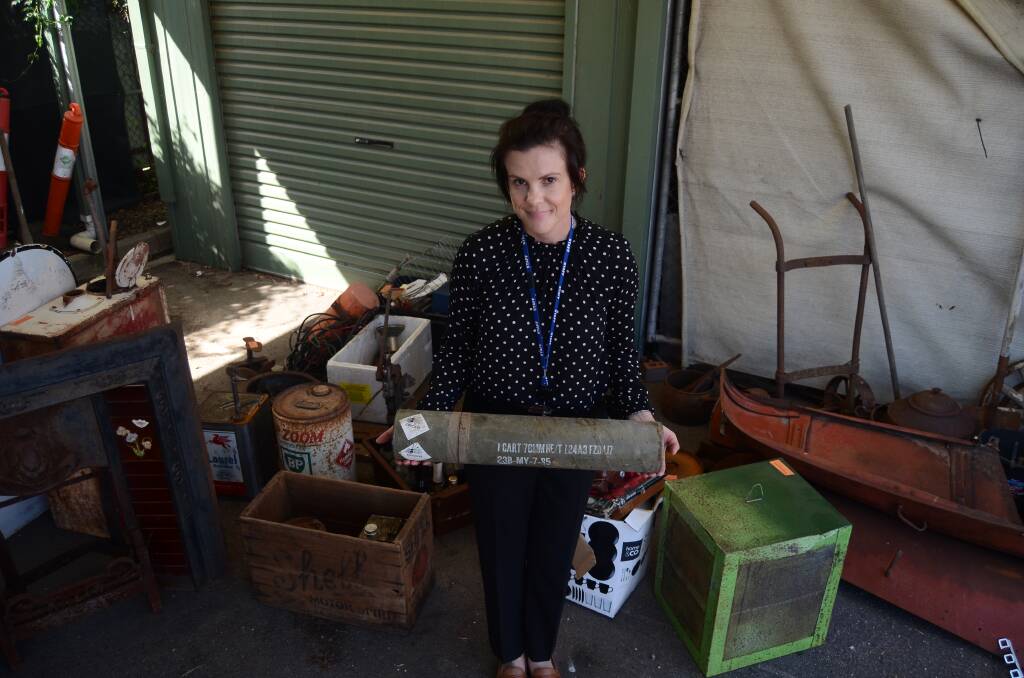 CACHE OF ITEMS: The detective with disused military equipment, antique vehicle parts, toy cars, a trolley, old fuel cans and a fireplace recovered during a search. Pictures: BLAIR THOMSON