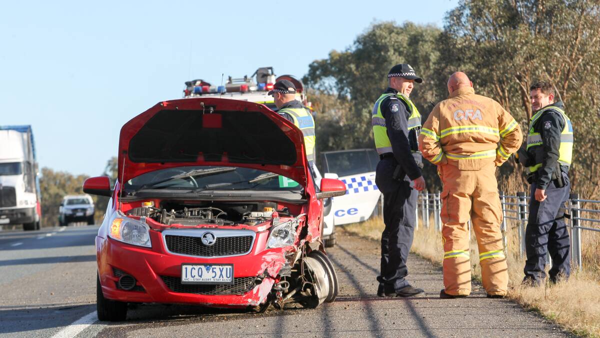 SAVED: Police on the scene of a collision in Wodonga last year. The Holden sedan was prevented from travelling down a large ditch by wire rope barriers. 