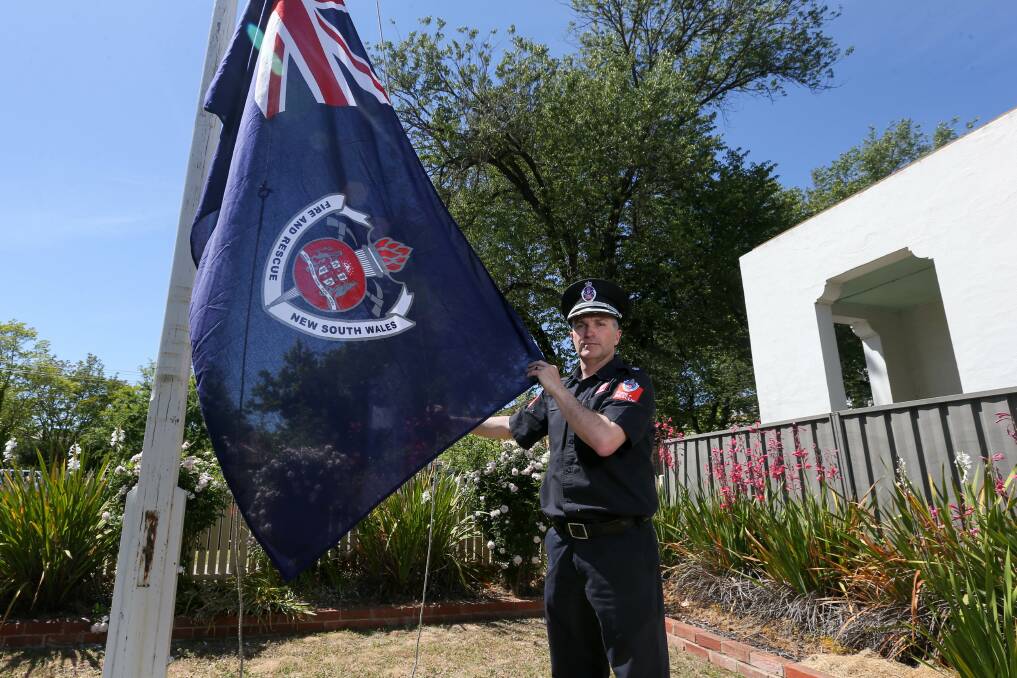 STOLEN: Inspector Frank Finlay with a flag similar to the one stolen from the Albury Central Fire Station. Picture: TARA TREWHELLA