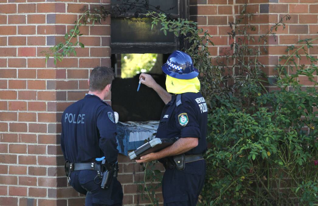 DAMAGE: Forensic officers at the front of the burnt out Mate Street home on Friday. Picture: BLAIR THOMSON