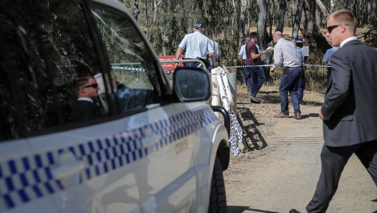 SEARCH: Police search through land at Mulwala after the murder. 