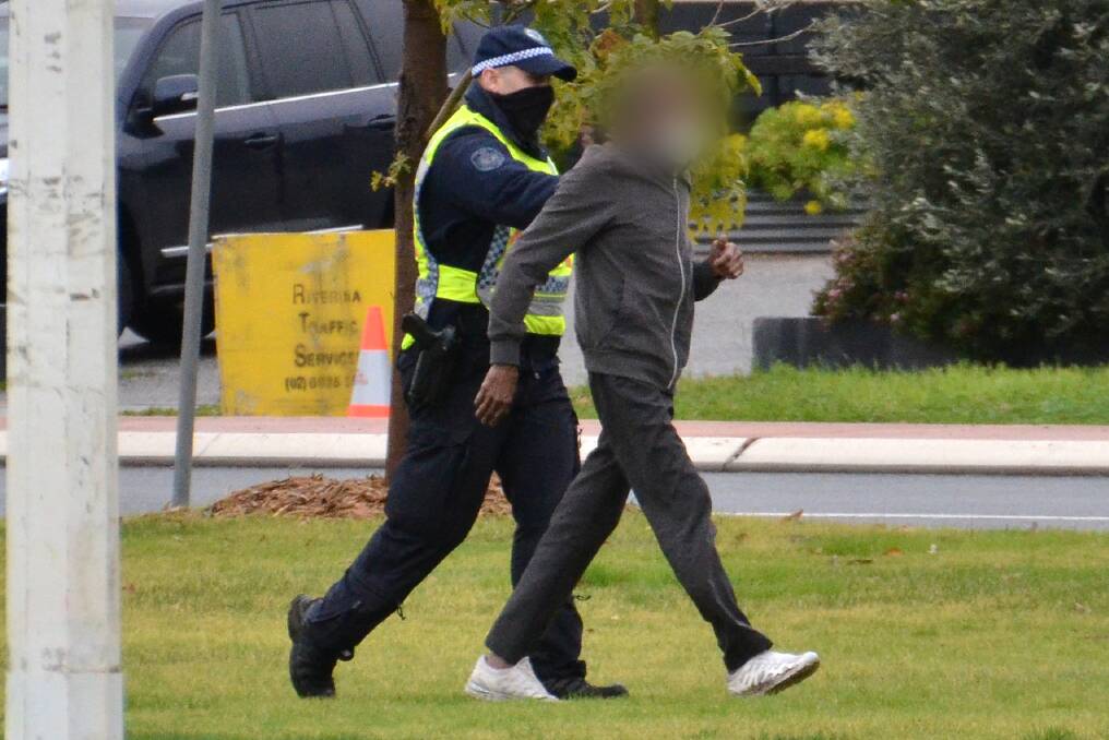 THWARTED: Police turn around a man at the oval near the Wodonga Place checkpoint in Albury on Thursday after he slowly ran towards town. Picture: BLAIR THOMSON