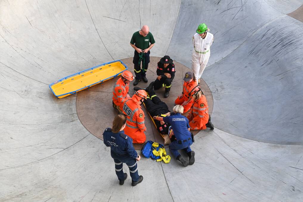 HELP ON HAND: The "patient" was assisted from the concrete skate bowl on Tuesday afternoon by people from four different agencies. Pictures: MARK JESSER