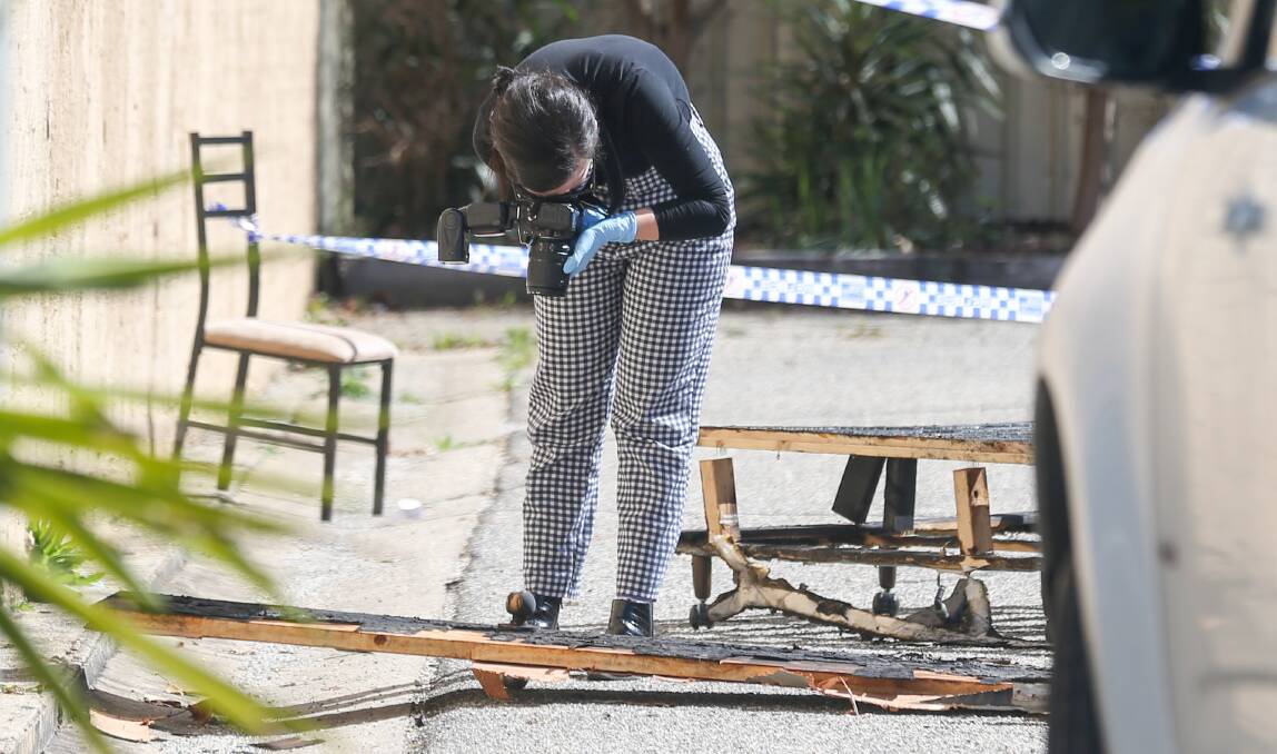 DAMAGE: A Victoria Police forensic officer examines damaged property at the Warrina Motor Inn following the blaze last August. 
