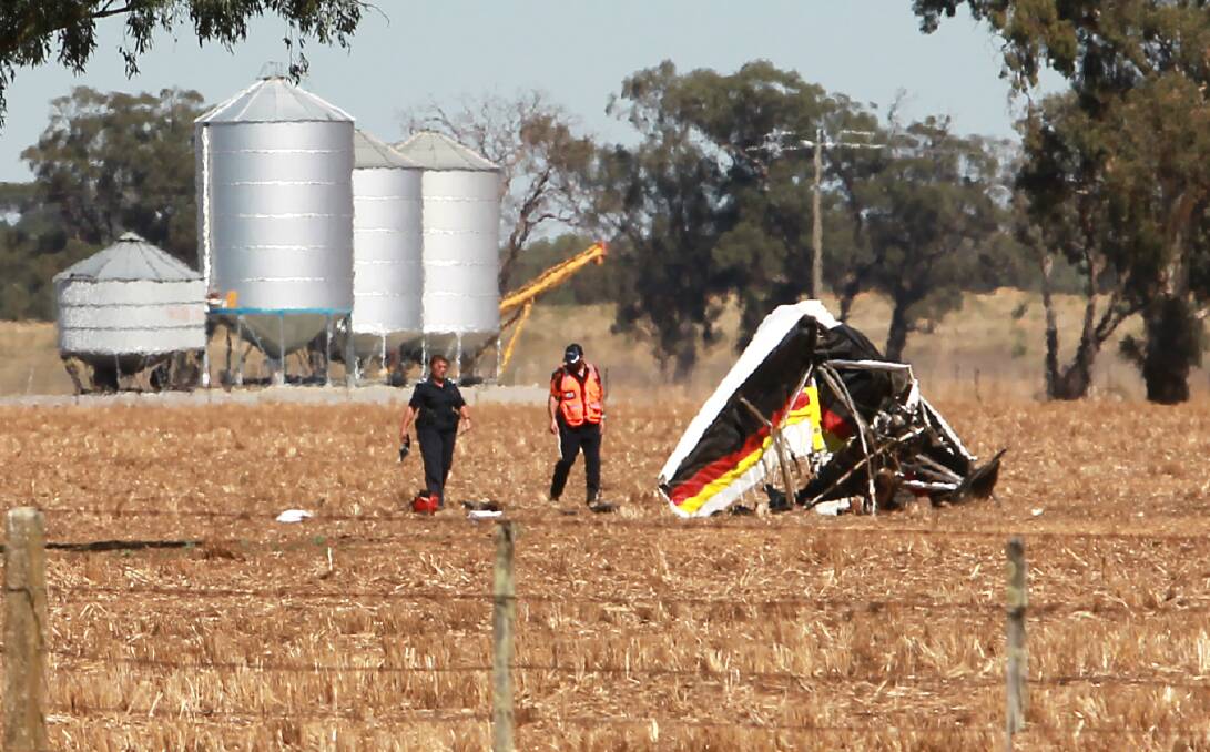 DAMAGE: Investigators inspect the damaged aircraft in a field at Yarrawonga on Monday morning. Picture: BLAIR THOMSON