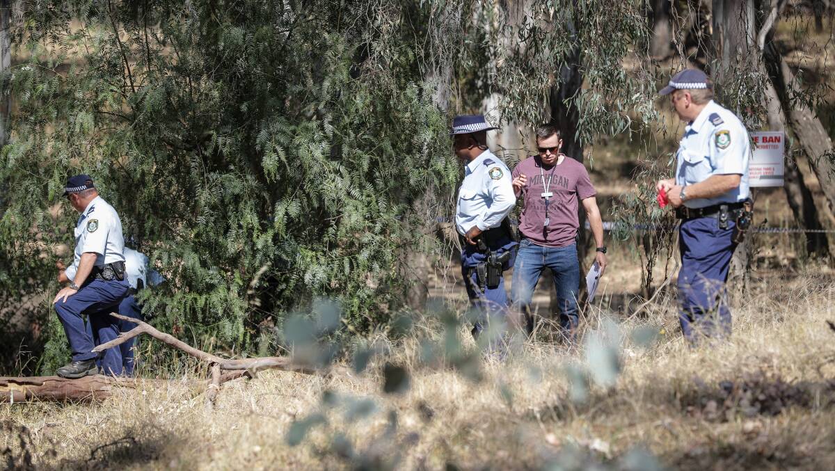 SEARCH: Police search through land at Mulwala after the murder. 