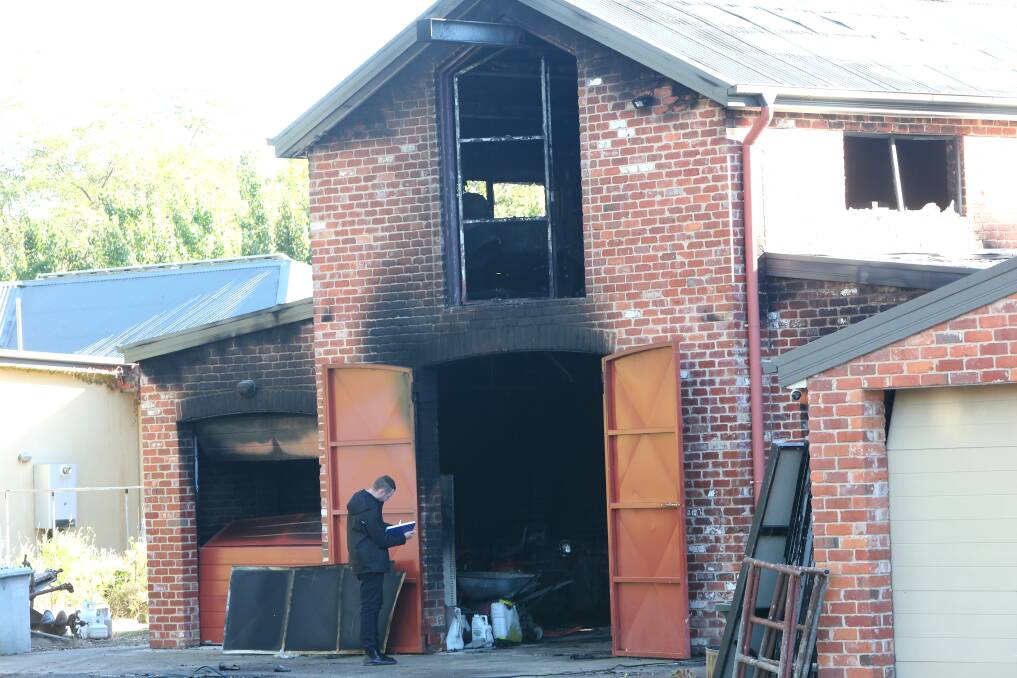 A detective at the scene of Friday morning's shed fire on Huon Creek Road in Wodonga. Picture by Blair Thomson