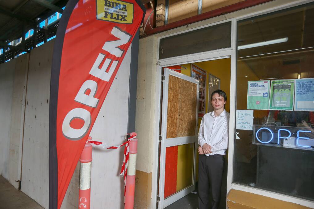 DAMAGE: Bira Flix worker Andrew Gillam next to the damaged door forced open by burglars in the early hours of Saturday morning. The neighbouring Asian restaurant was also broken into about the same time. Police are investigating. Picture: TARA TREWHELLA