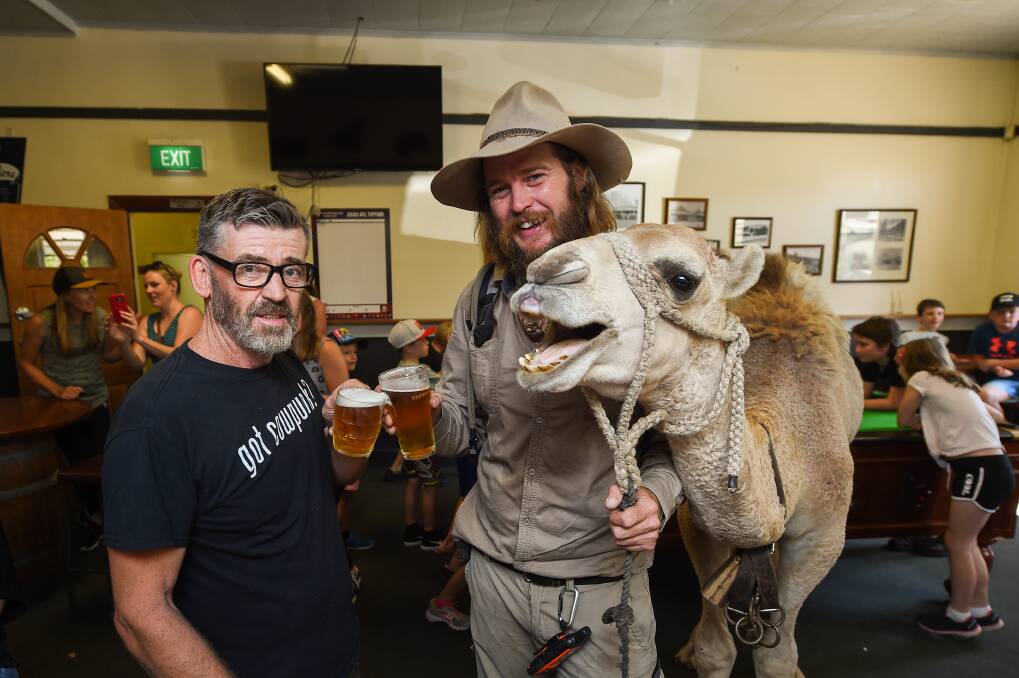 THIRSTY WORK: Tangambalanga publican Anthony Keck enjoys a drink with John Elliott and his camel, Charlie, at the venue. The unique event raised about $500 to support a skin cancer charity. Pictures: MARK JESSER