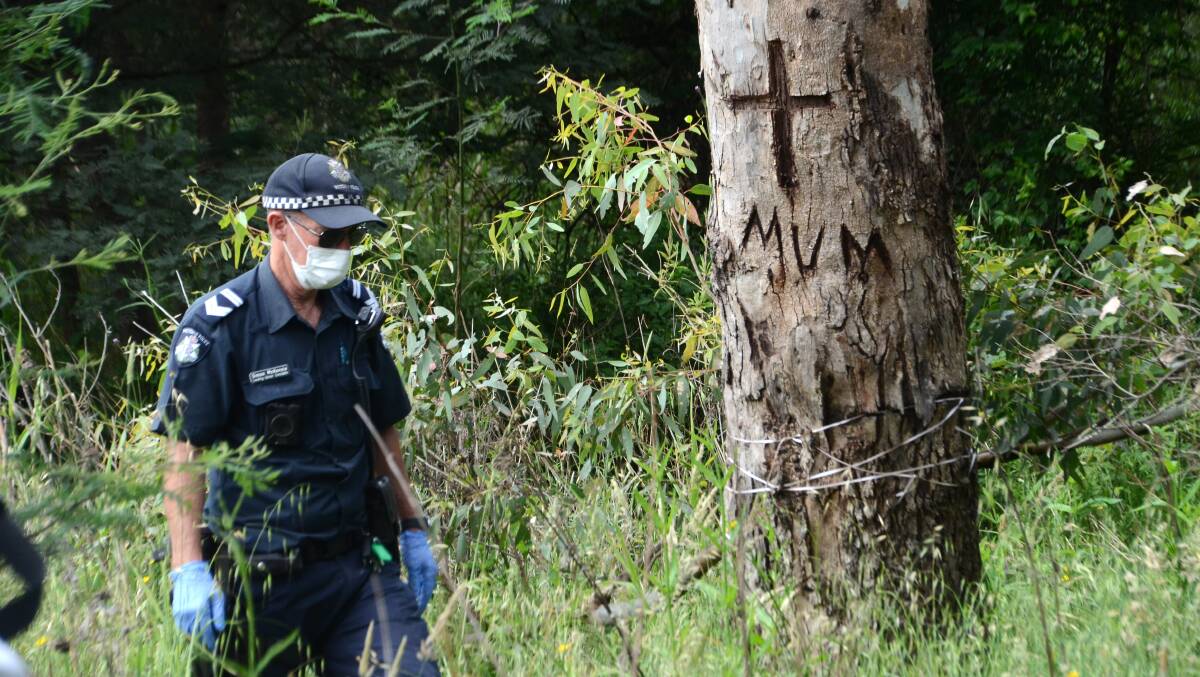 TRIBUTE: Police scour the area near a tribute carved for Ruth Ridley in a tree on Wednesday. Pictures: BLAIR THOMSON