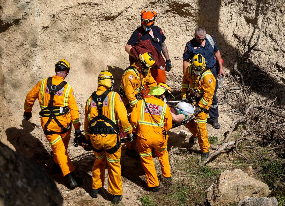 ASSISTANCE: CFA members help bring the woman to safety. Pictures: JAMES WILTSHIRE