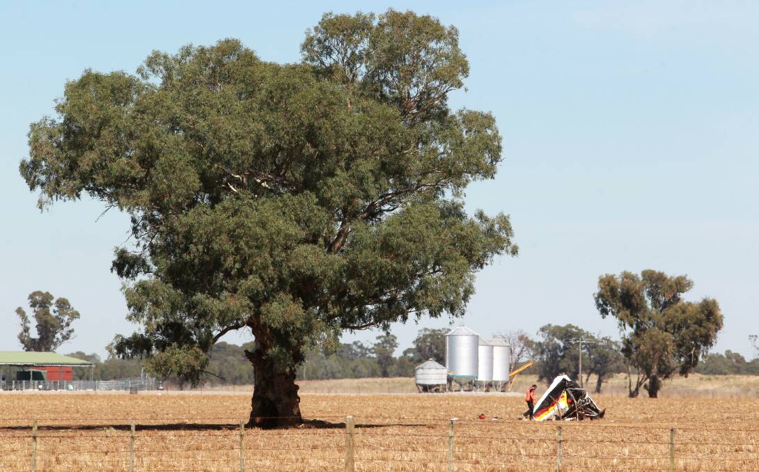 DAMAGE: An investigator inspects the damaged aircraft in a field at Yarrawonga on Monday. Picture: BLAIR THOMSON