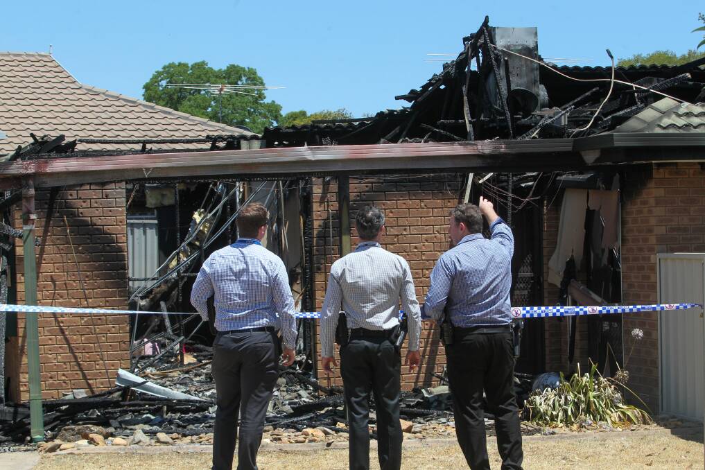 DAMAGE: Detectives at the Wodonga home on New Year's Day. 