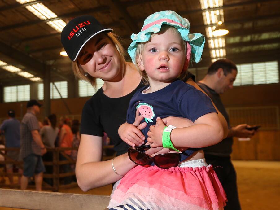 PETTING ZOO: Nadia McKendrick and her two-year-old daughter, Gracie, check out some of the animals at the event, which included lambs, calves and chickens. 