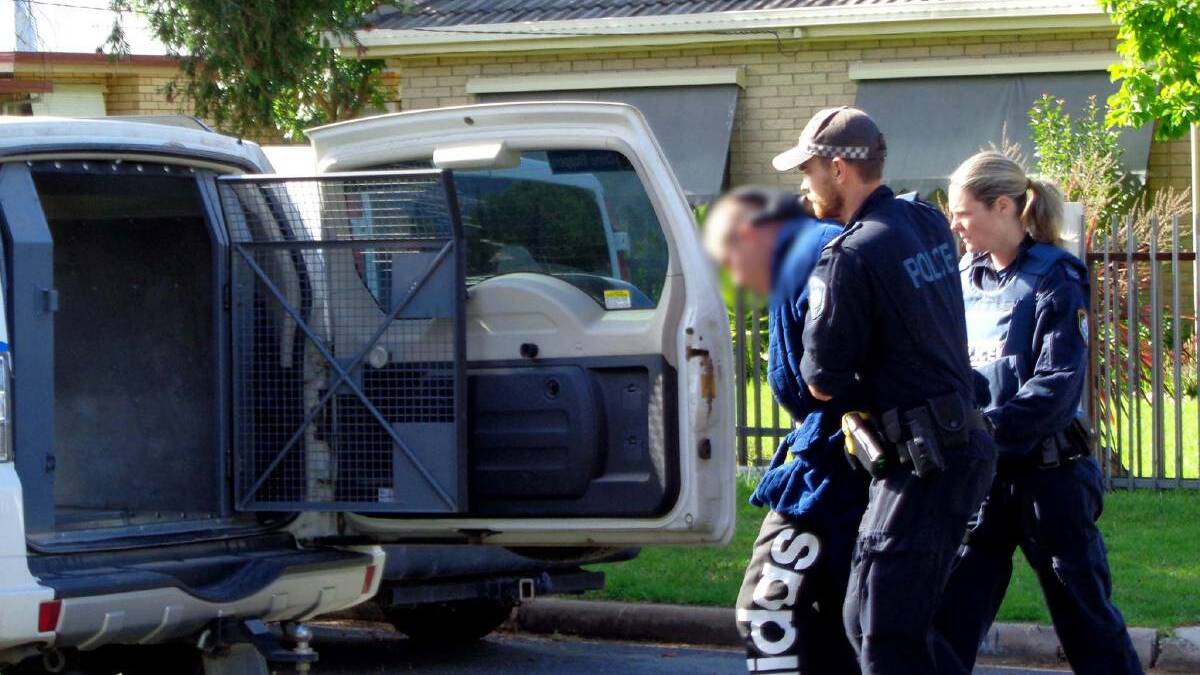 RAIDS: Police execute search warrants on Kooba Street last year as part of the investigation. 