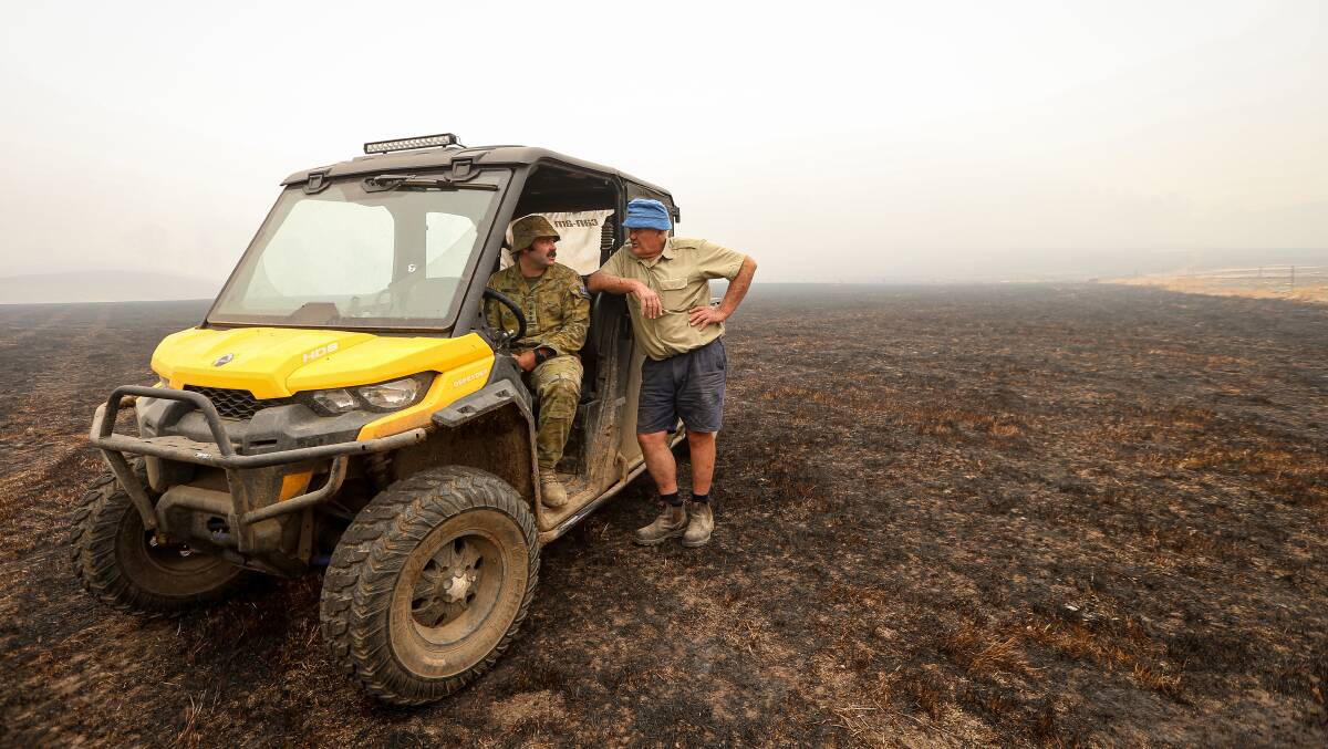 SCORCHED: Captain Tyrell and his father, in burnt farmland this week. Pictures: JAMES WILTSHIRE