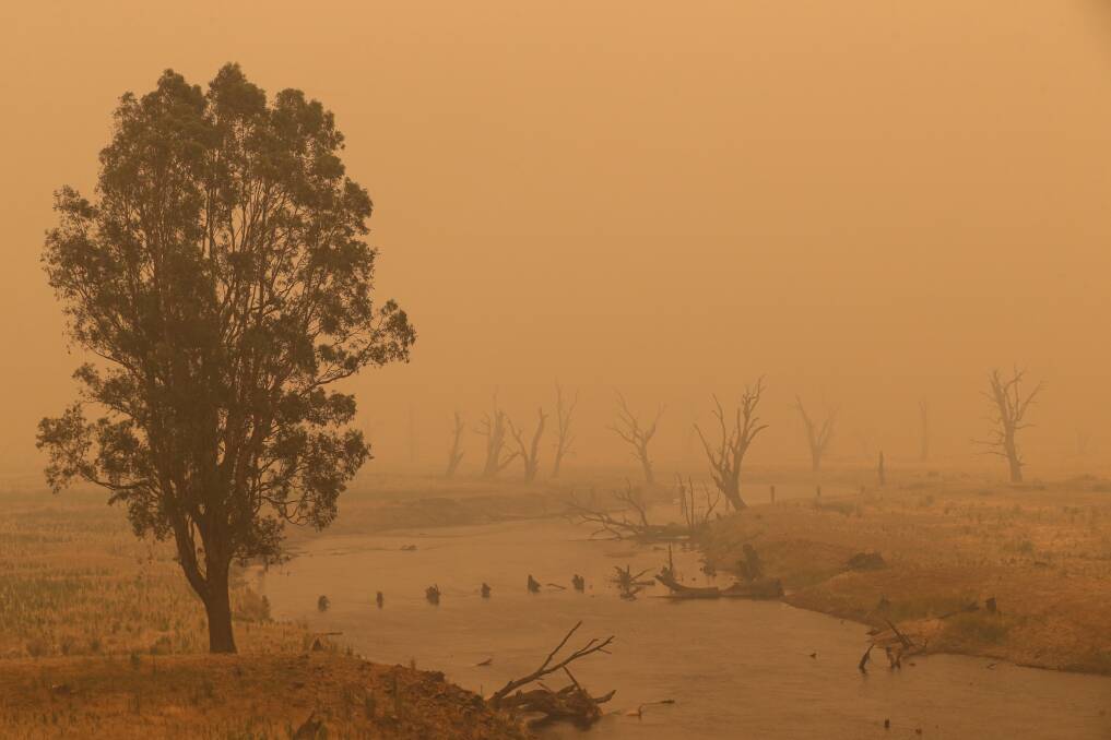 SMOKE HAZE: The sky was a dark orange over the Mitta River at Tallangatta on Sunday from smoke from the Upper Murray and southern NSW fires. Picture: JAMES WILTSHIRE
