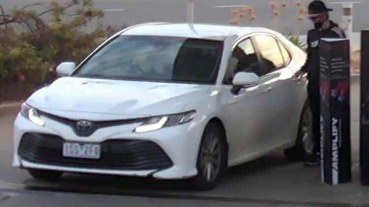 STOLEN: The Toyota Camry hybrid, with false plates, pictured on security camera being filled up by an unknown person. 