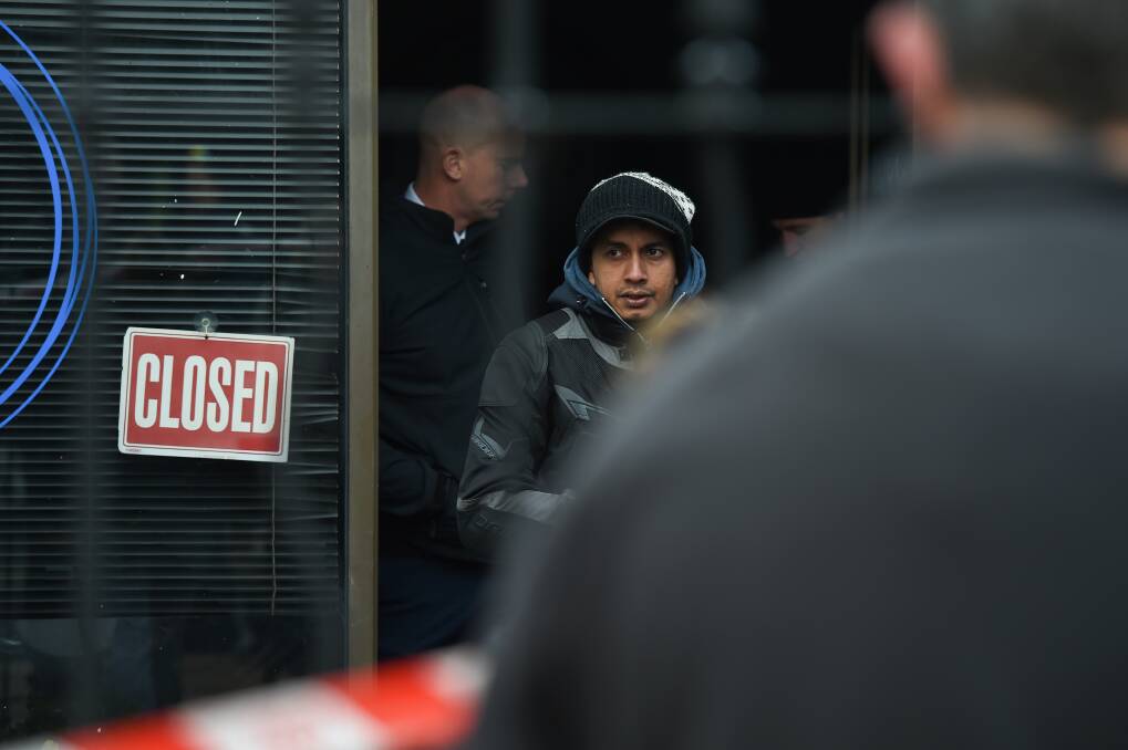 ON SCENE: Pereira, pictured with police outside his torched business hours after he set it alight. 