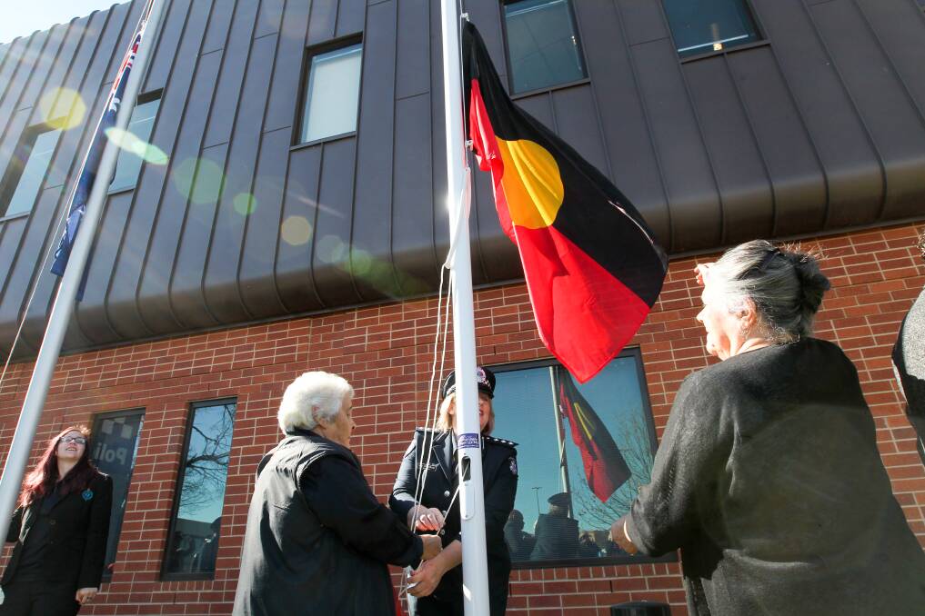 SYMBOLIC: Members of Indigenous community, including Edna Cameron and Pam Griffin, helped raise the Aboriginal flag with Inspector Joy Arbuthnot outside the Wodonga Police Station. Picture: BLAIR THOMSON
