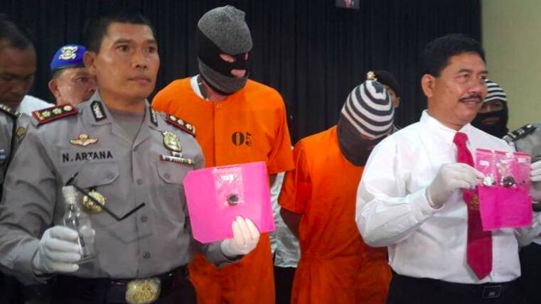 Police with Australian Giuseppe Serafino (in orange prison clothes, right) and Briton David Fox, who have been arrested for allegedly possessing hashish in Bali. Photo: Amilia Rosa