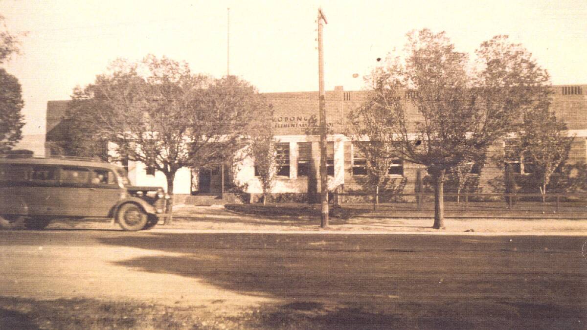 SCHOOL TIME: Wodonga Higher Elementary School and Tallangatta school bus, c.1954. The school opened in 1857.