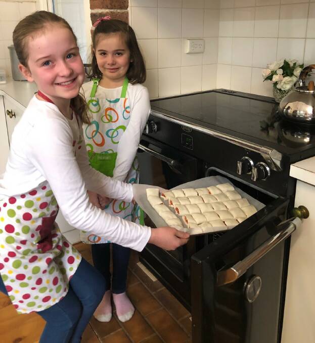 COOK-UP: Daisy and Jemima McKay cooking up a storm for their mum Gina.