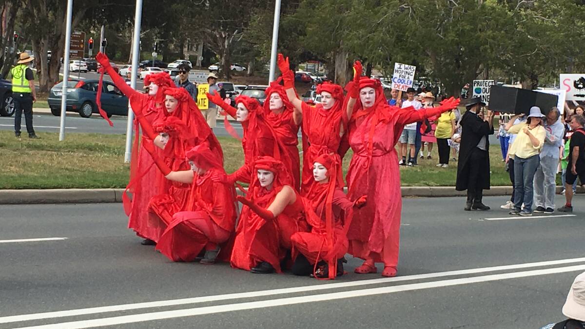 The Extinction Rebellion's Red Rebels performers lead the Canberra street march. Picture: Peter Brewer
