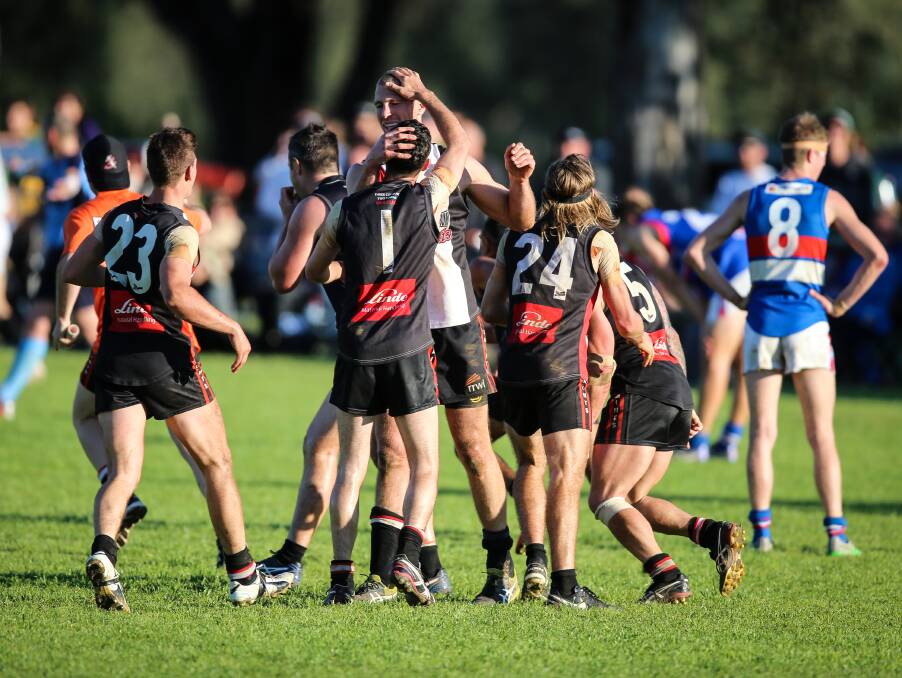 YOU LITTLE BEAUTY: Brock-Burrum players congregate after the Saints won their third flag in four seasons.