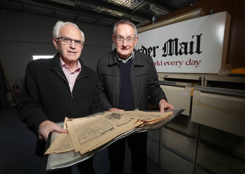 LOOKING BACK: Albury and District Historical Society president Greg Ryan and historian Dr Bruce Pennay examine a copy of The Border Morning Mail from 1939.