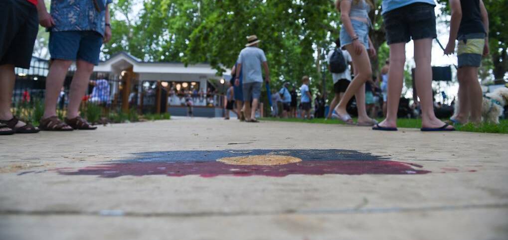 An Aboriginal flag on the footpath of Albury's Noreuil Park on Australia Day. Picture: MARK JESSER