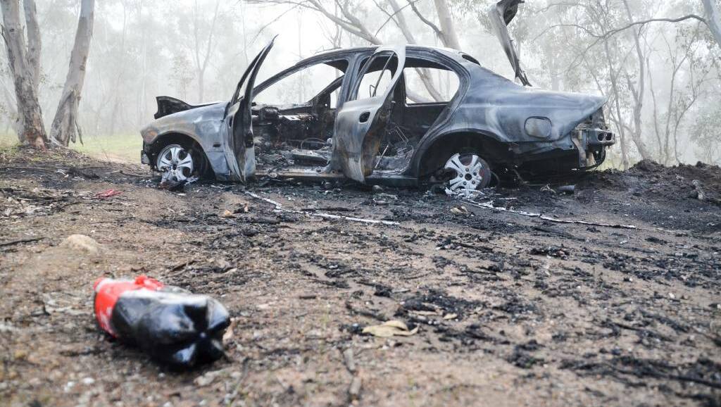 SET ALIGHT: The Ford Falcon was driven up a track on Nail Can Hill in West Albury before being set alight. The occupants fled from the scene.