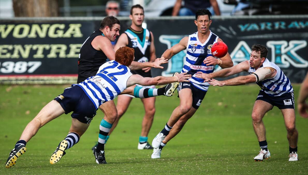 SHARP DELIVERY: Lavington star Matt Sharp gets a kick away as Yarrawonga duo Damon Symes and Craig Ednie attempt to smother. Picture: JAMES WILTSHIRE
