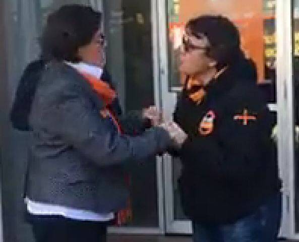 Cathy McGowan and union official Wil Stracke "hold hands" outside the Indi MP's Wangaratta office on Thursday.