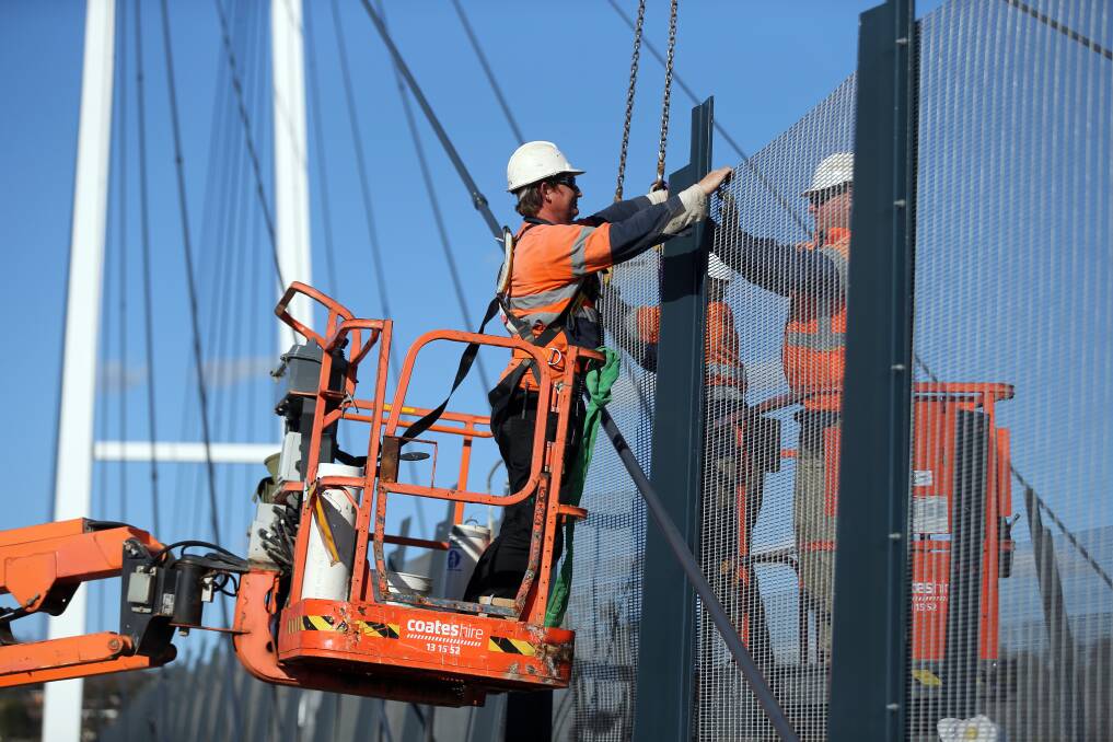 Workers installing higher barriers on the Harold Mair Bridge over the Hume Highway in Albury in 2012.