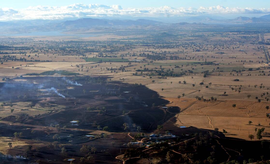 An aerial picture of burnt farmland south-east of Gerogery after the blaze (with Lake Hume seen in the background). Picture: MATHEW SMITHWICK