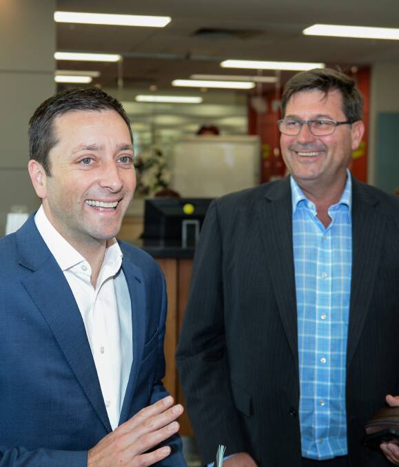 Happy days: Matthew Guy and his Liberal colleague Bill Tilley after their tour of Mars Petcare in Wodonga on Wednesday. During his visit Mr Guy helped Mr Tilley celebrate 10 years in parliament. Picture: MARK JESSER