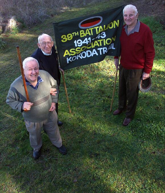 Kokoda soldiers: Frank Gould, Wally Moras and Jack Withers pictured with the battalion's banner back in 2002. 