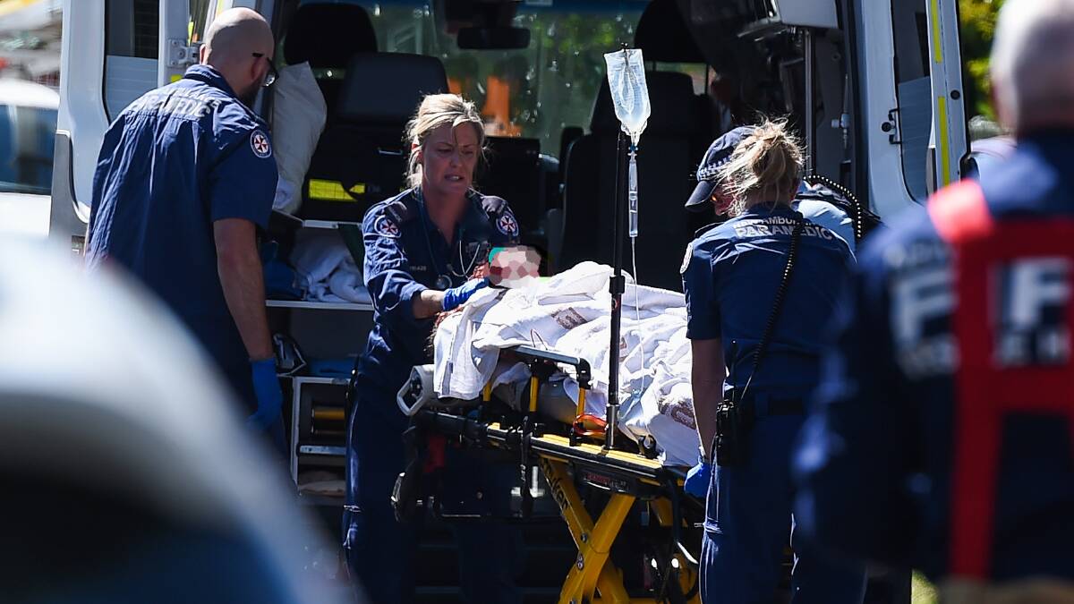 Paramedics attend to "Amy" after she was rescued from the flames that engulfed her Swan Street, North Albury, home, on November 11, 2019.