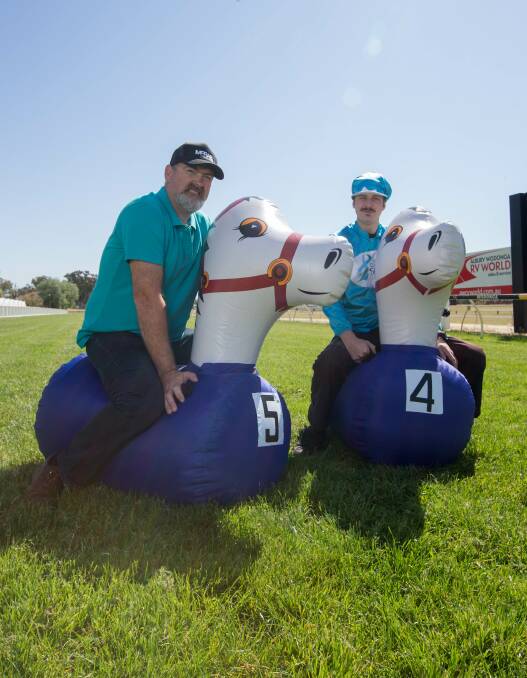 CANCER CAUSE: Angus Webster and Sam Hiotis check out their mounts for Saturday's Border Ovarian Cancer Awareness Group charity race at Wodonga. Picture: TARA TREWHELLA