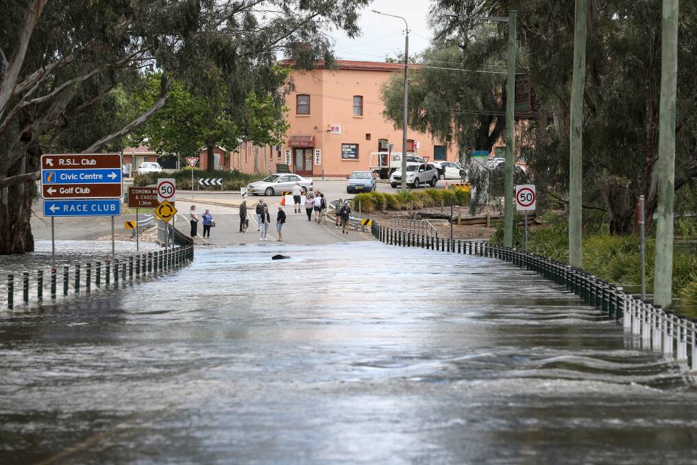 Corowa residents have a look at Bridge Road, which is covered with water, on Monday. Picture by James Wiltshire