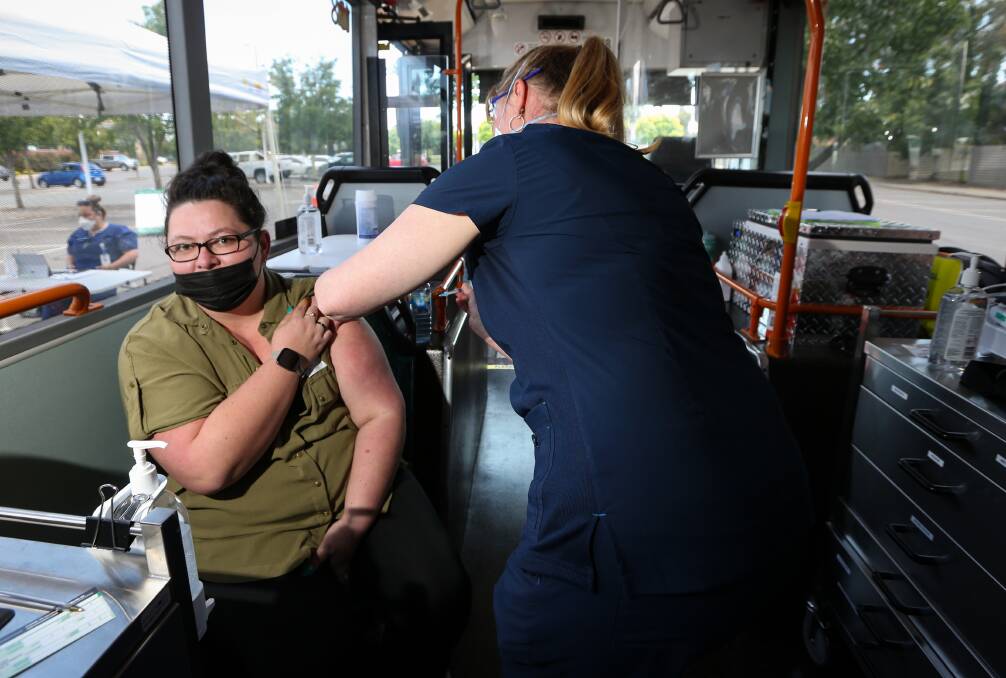 CONVENIENCE: Living just around the corner encouraged Wodonga's Peta Sellers to roll up her sleeve and receive her first COVID-19 vaccination on Wednesday in the mobile clinic bus. Her two older children did likewise. Picture: JAMES WILTSHIRE