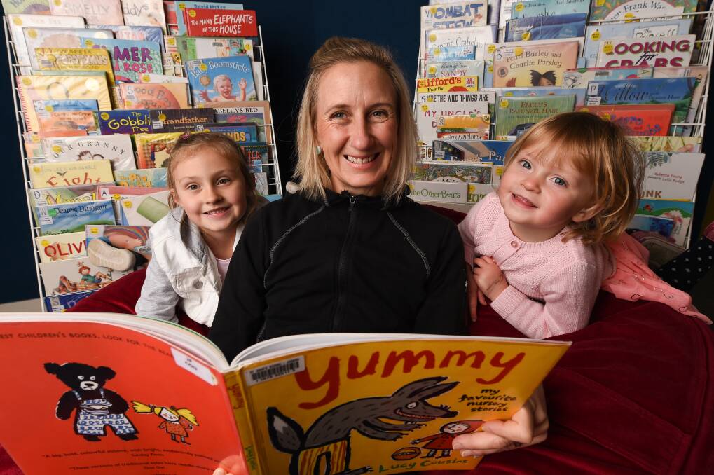 READING TOGETHER: Melissa Petzke-Butler shares some favourite nursery stories like Little Red Riding Hood and The Three Little Pigs with her children Alanta, 5, and Azalea, 2, in the St John's School library. Picture: MARK JESSER